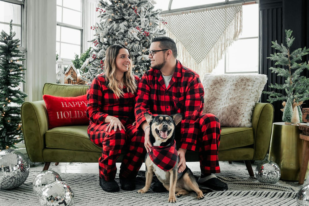 Couple and their dog in matching red plaid Christmas outfits